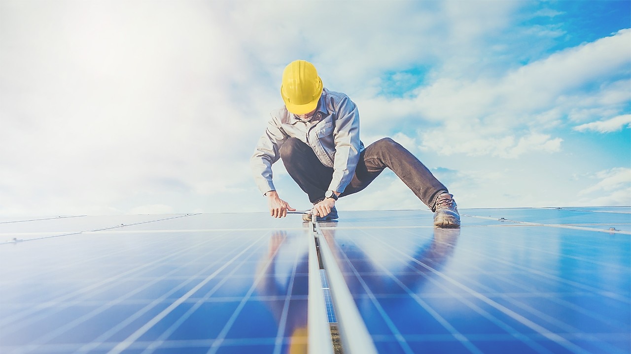 A worker doing maintenance on solar panel