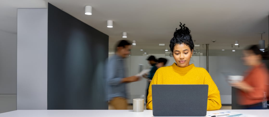 Lady wearling yellow jumper in busy office