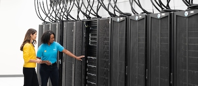 Two women examining a data centre