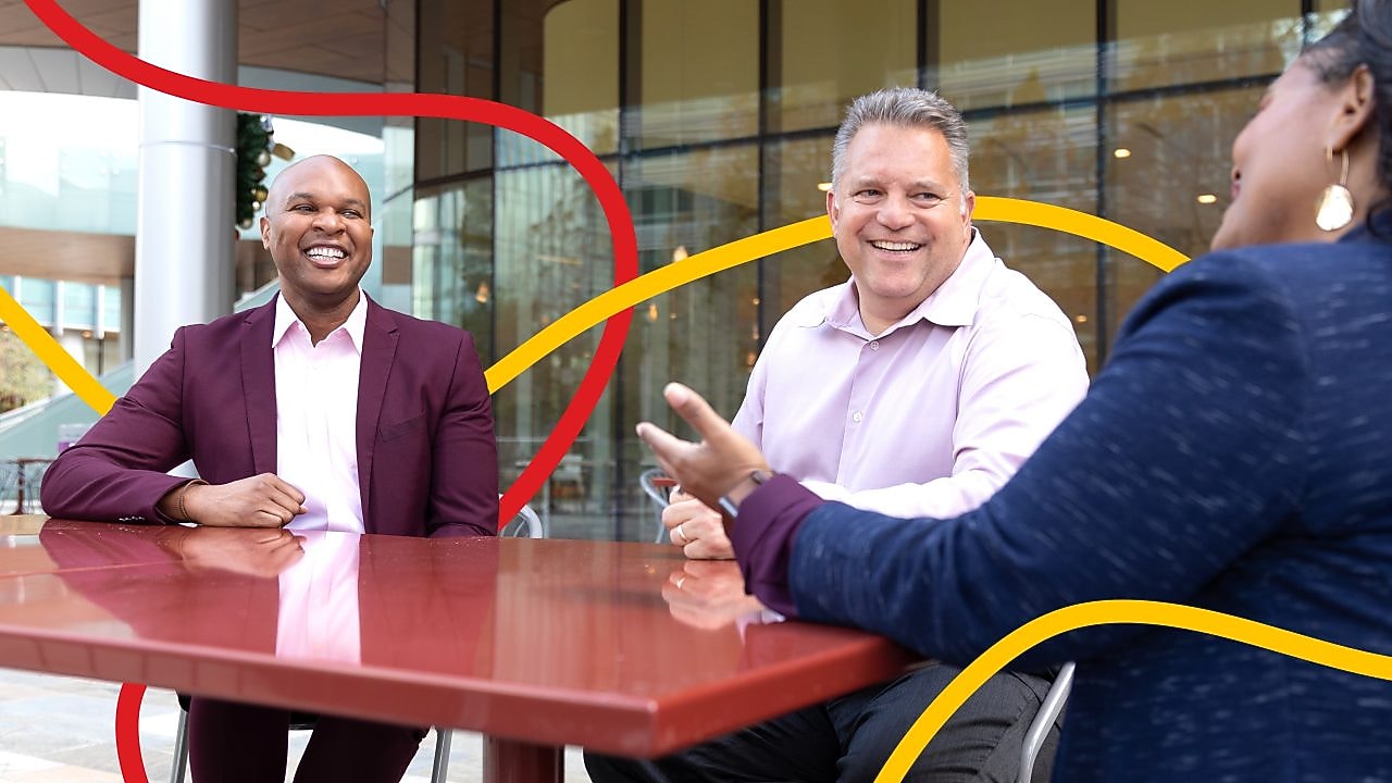 Three people chatting and smiling