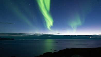 Aurora borealis over calm water, representing carbon storage initiatives in Northern Europe.