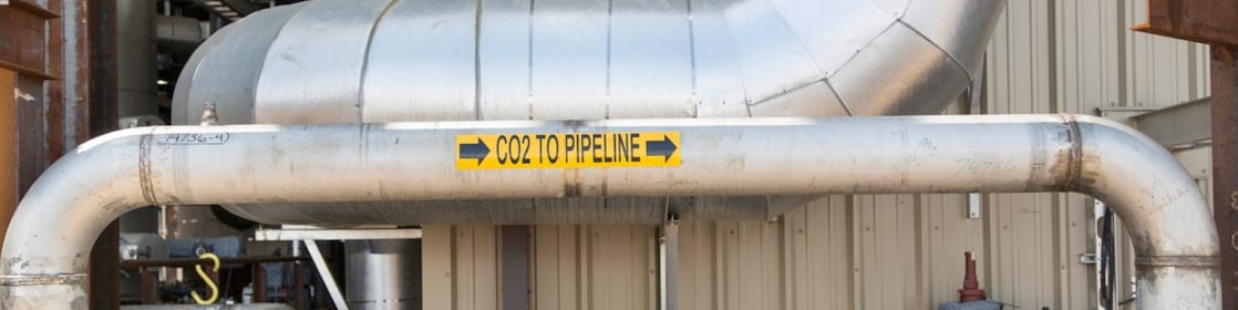 image of a pipeline transporting CO2 from for safe and permanent underground storage. The pipeline has a sticker on it indicating the direction of flow of CO2.