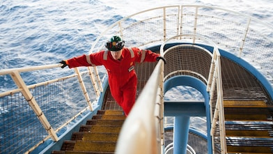 Platform Well Site Drilling Engineer ascending the stairs on an offshore platform.