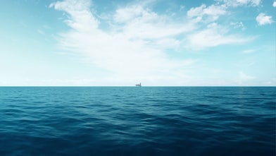 Image showing a horizon between the ocean and the sky. On the horizon, far in the distance in an offshore platform