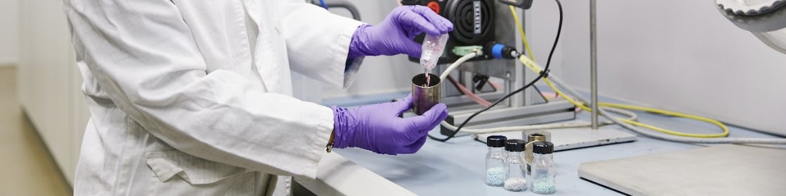 Industrial catalysts in pellet form manipulated by a researcher
