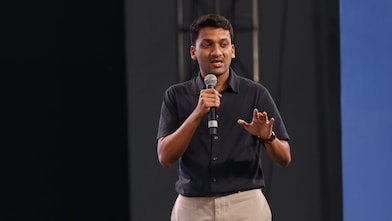 a man holding a microphone, speaking