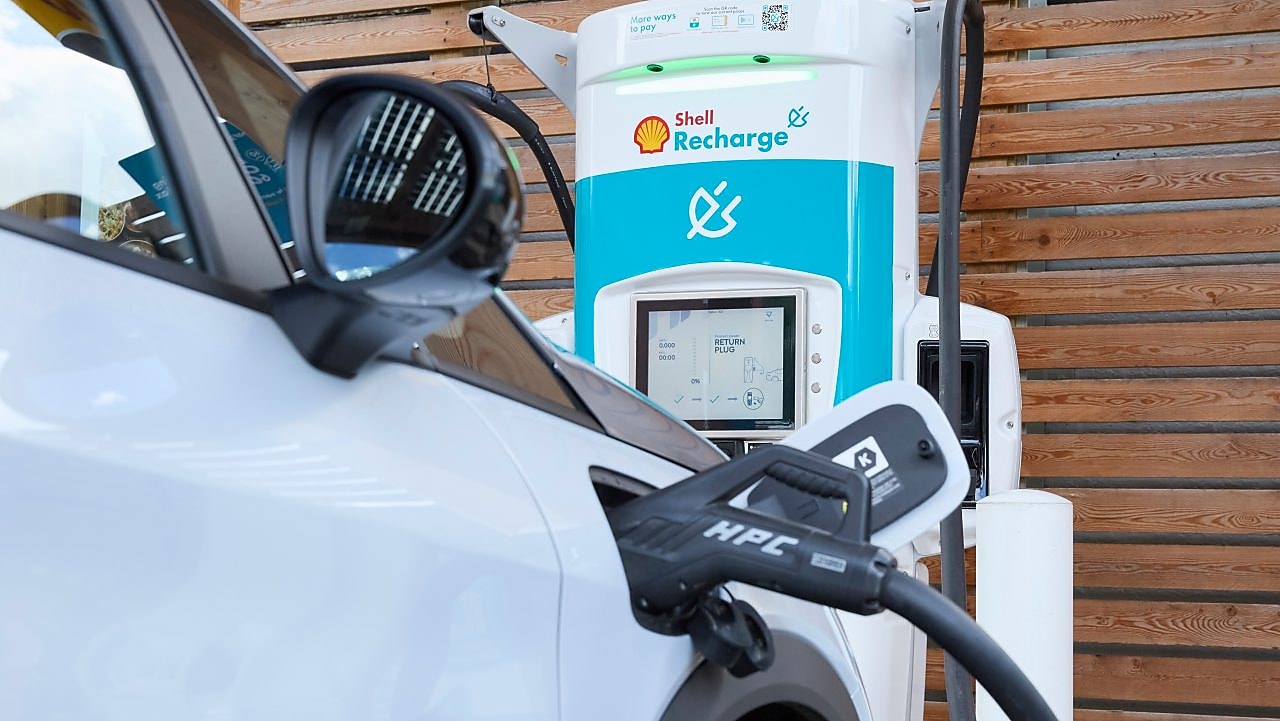 two electric vehicle charge posts where one of the posts is charging a car