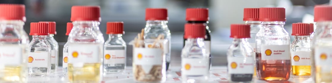 Selection of Shell GTL product samples in glass bottles.