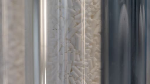 Catalyst beads shown inside laboratory glassware.