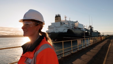 Shell LNG Dragon female technician in front of the ship