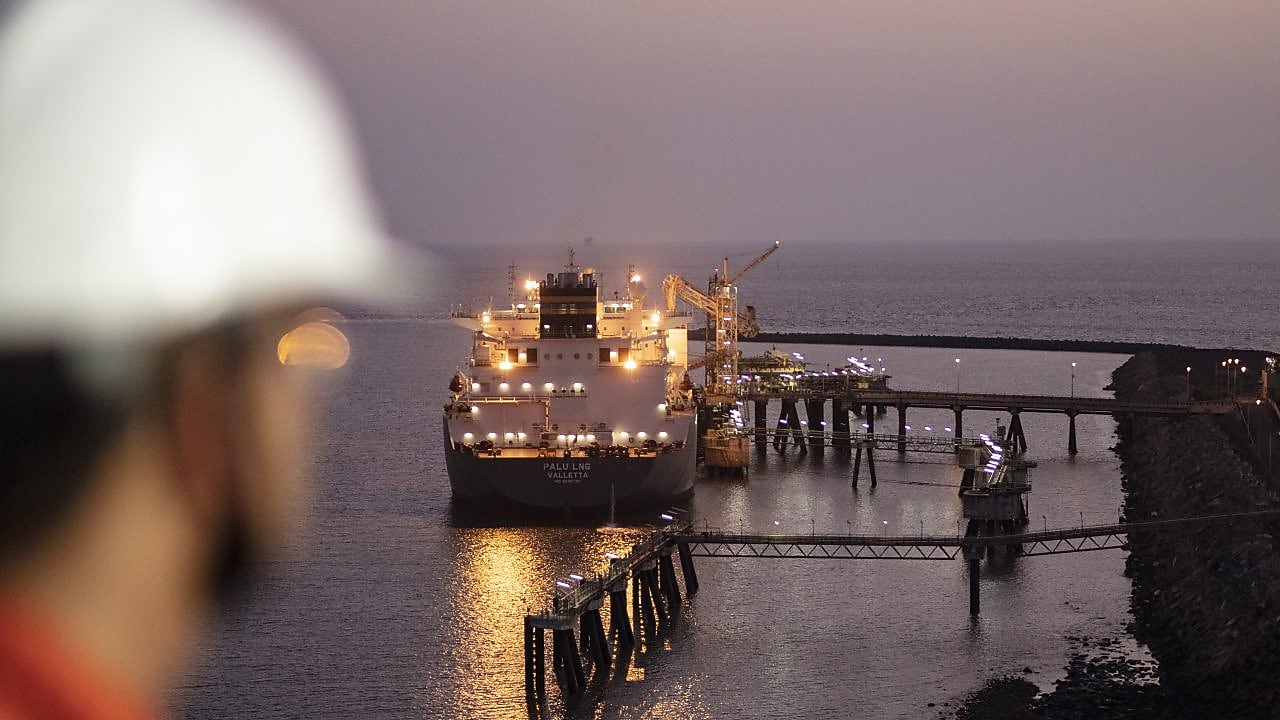 A male crew overlooking docked LNG ship