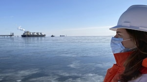 Female crew wearing face mask overlooking the LNG vessel from a snowy coast