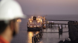 A male crew overlooking docked LNG ship