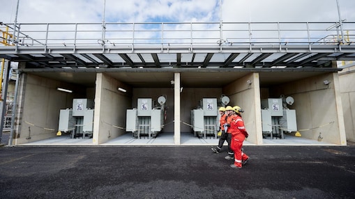 Staff walk past rectifier transformers at the plant