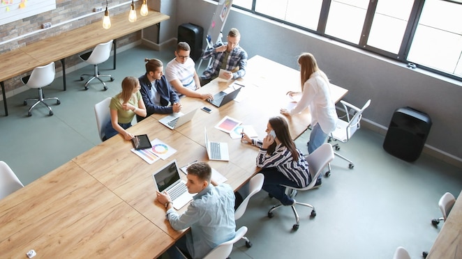 A view from above of young people having business meeting in modern office.