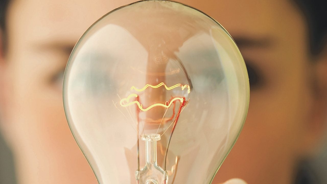 Woman holding a light bulb in front of her face