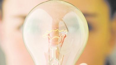 Woman holding a light bulb in front of her face