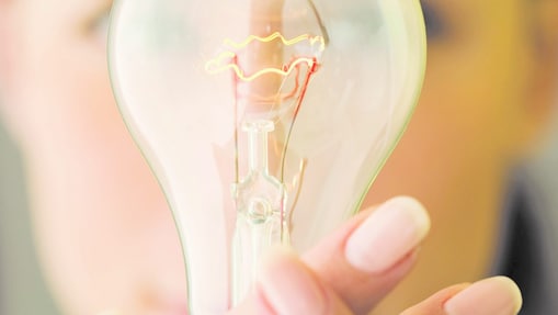 Woman holding a light bulb in front of her face