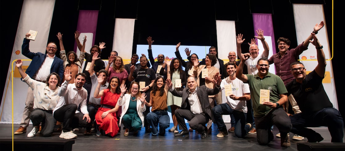 A group of people stands on stage at a Demo Day event.
