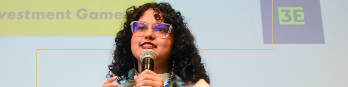 A presenter speaks at the SSE 2024 Brazil Investment Game, gesturing in front of a slide.