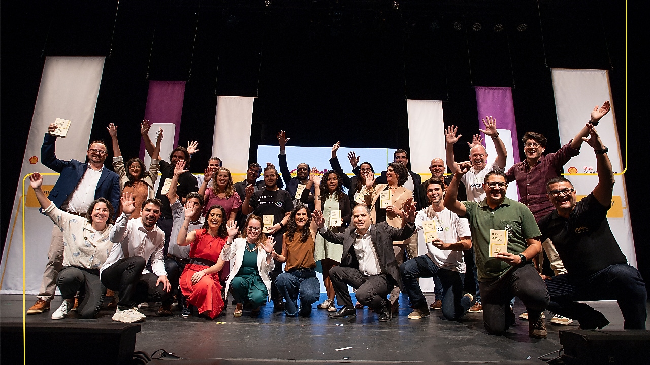 A group of people stands on stage at a Demo Day event.