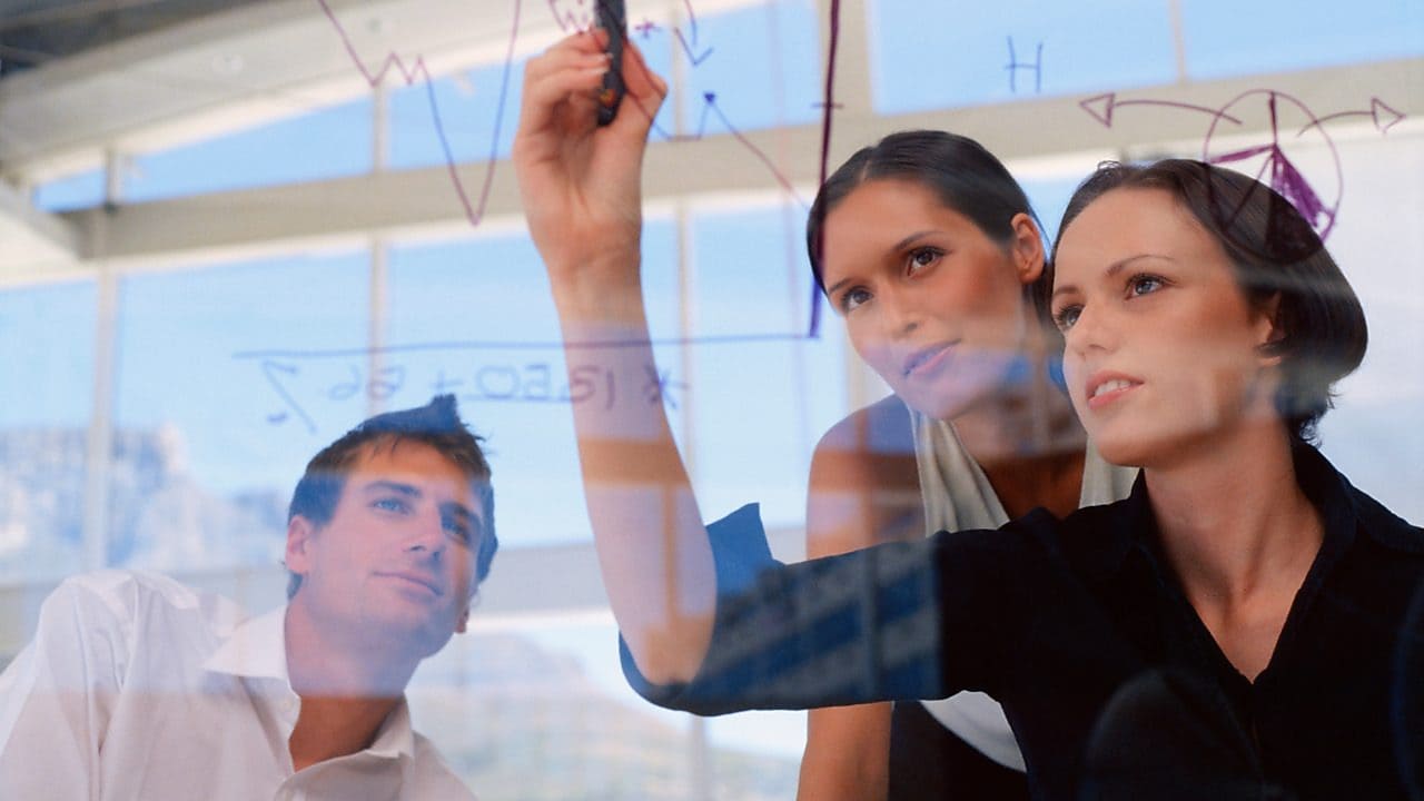 Businesswoman drawing graphs on glass