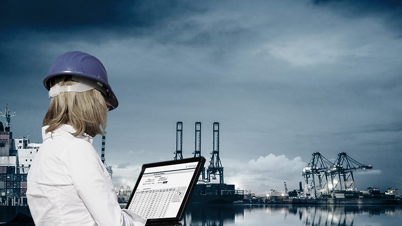 women holding aptop in hand working at plant side