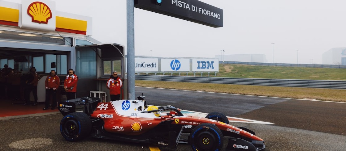Shell scientists and Scuderia Ferrari HP drivers conversing in the Shell Trackside Laboratory at a Grand Prix circuit