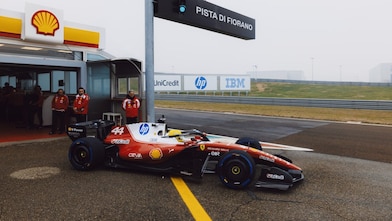 Shell scientists and Scuderia Ferrari HP drivers conversing in the Shell Trackside Laboratory at a Grand Prix circuit