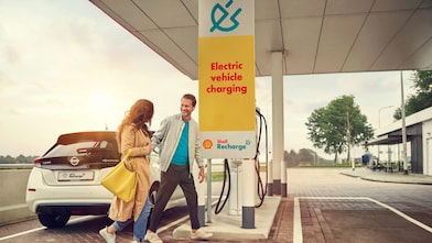 A man and women walking near electric car charging