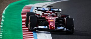 Ferrari F1 car driving on racetrack.