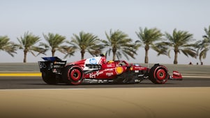 Ferrari F1 car racing on sunny track with palm trees
