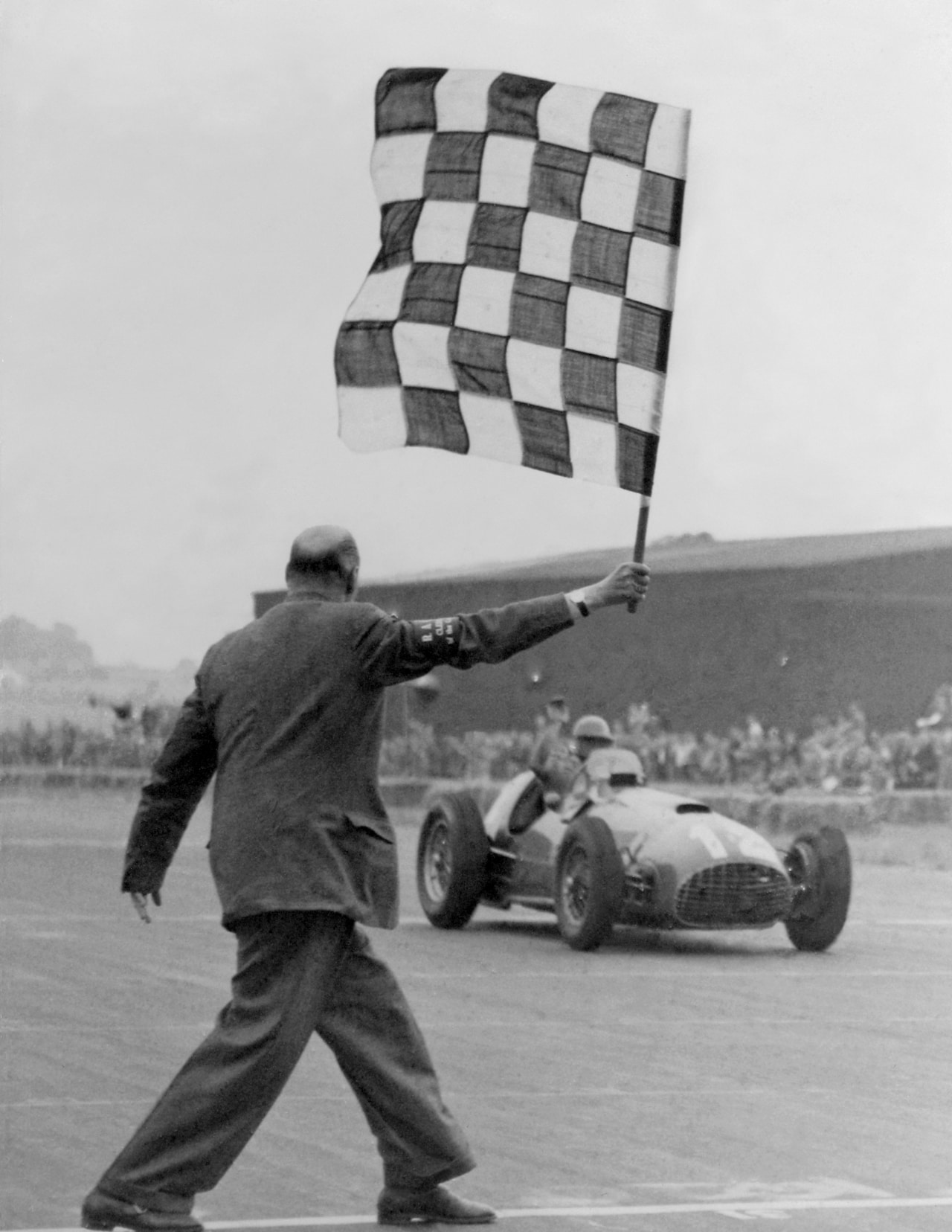 José Froilán González driving a Ferrari 375 F1 across the finish line at the 1951 British Formula 1 Grand Prix at Silverstone. 