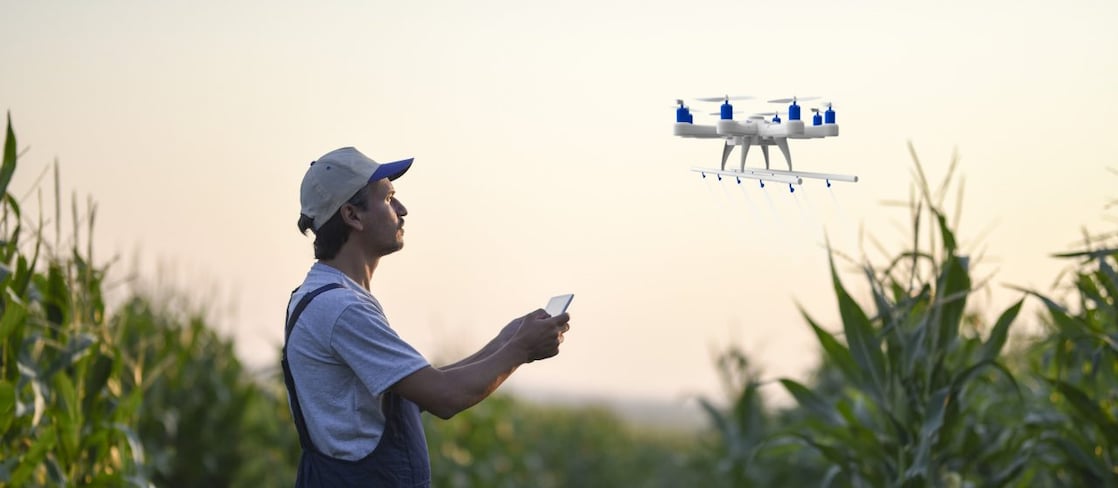 A farmer spraying crops using a drone