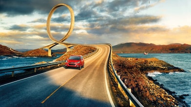 Car on the road with surroundings of sea and mountains