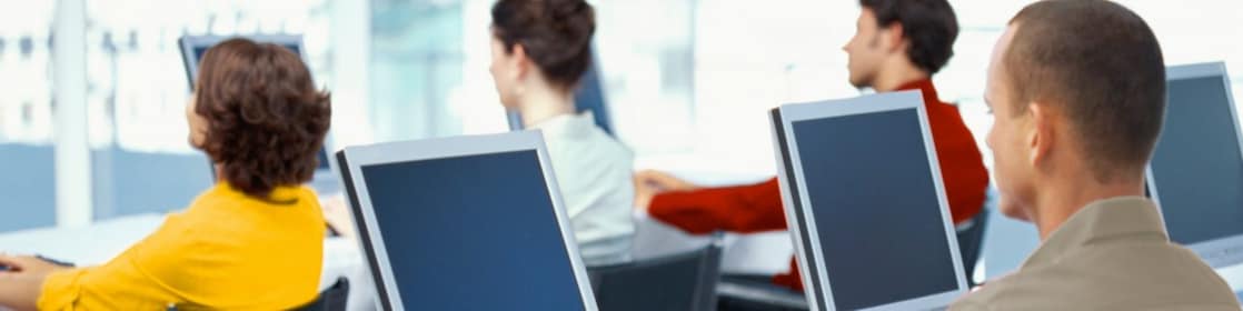 rear view of four business executives using computers in an office