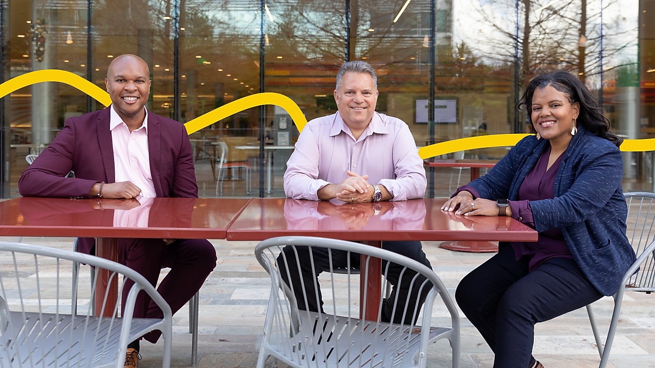 Three people sitting in an open space