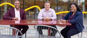 Three people sitting in an open space