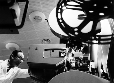 Man operating old reel to reel camera