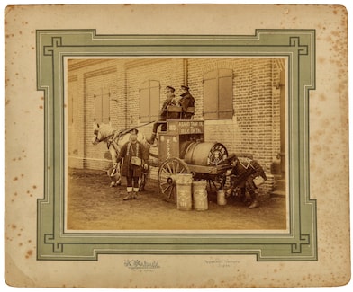 Horse pulling a cart and two people