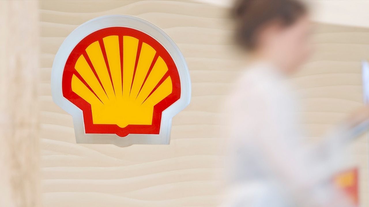 Shell sign with employee climbing steps in the background