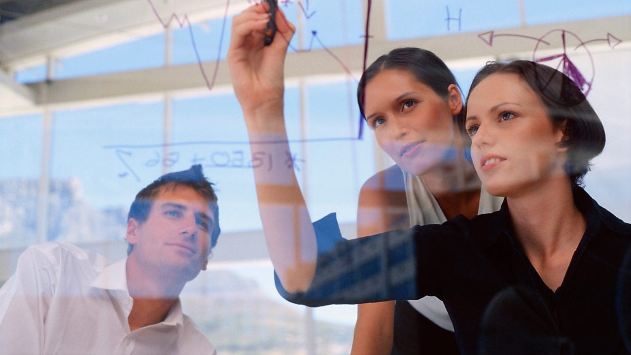 Businesswoman drawing graphs on glass